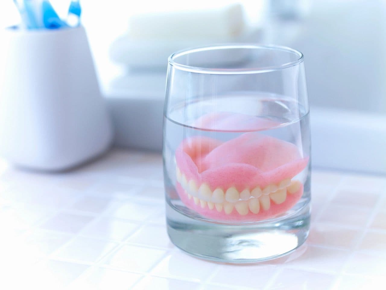 Photo of dentures soaking in a clear glass